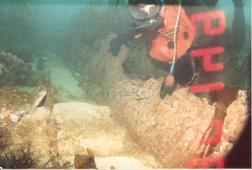 The diver is holding onto a piece of the wooden hull.(Sorry about the time stamp)