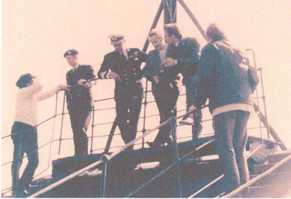 The Captain ofHMS Kinbrace [left] standing next to the aide of the C in C Portsmouth and the Conunander in Chell [third from left] discussing the lift of HM Submarine XE8.